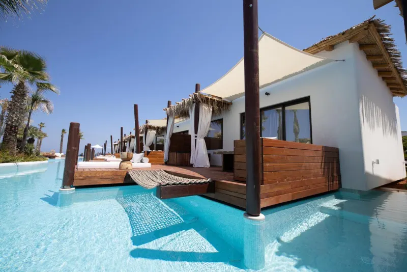 Wooden walkway over pool leading to bungalows