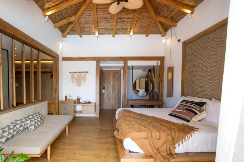 Spacious bedroom with wooden beams and seating area