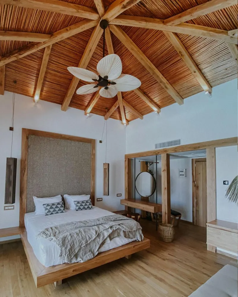Bedroom with vaulted thatched ceiling and wooden bed frame