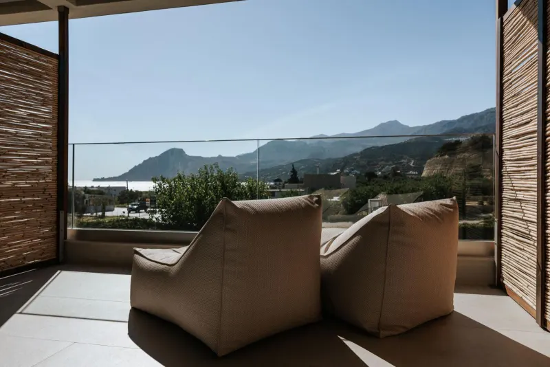 Two lounge chairs on balcony with mountain view