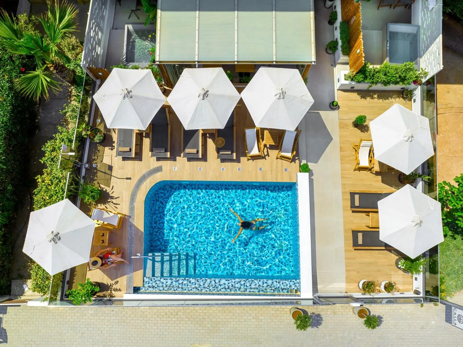 Aerial view of pool with umbrellas and swimmer