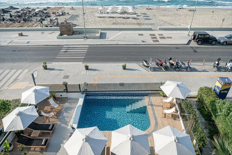 Aerial view of rooftop pool beside road and beach