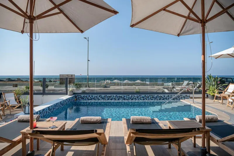 Rooftop pool with loungers facing the sea