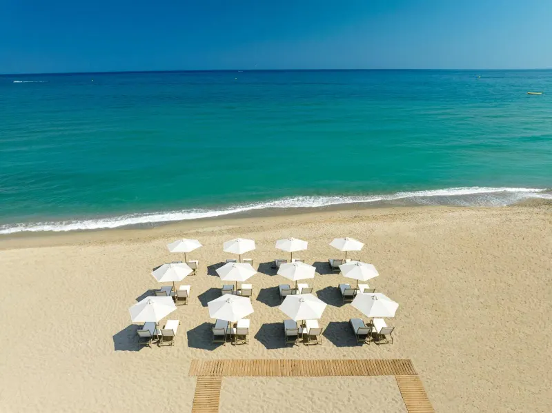 Aerial view of beach loungers lined on sand