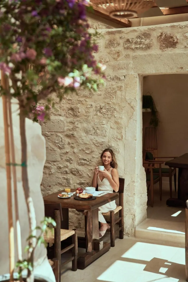 Woman having breakfast in stone courtyard