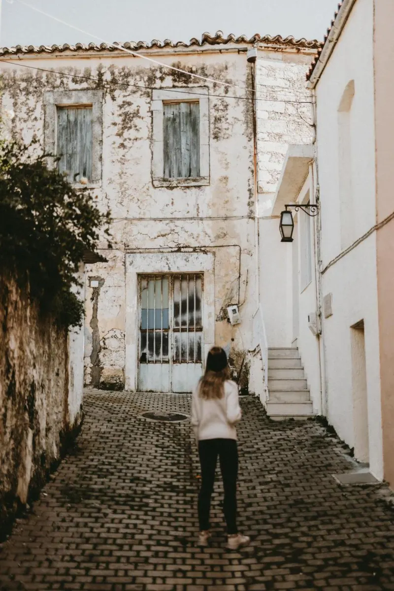 Woman walking through historic cobblestone alley