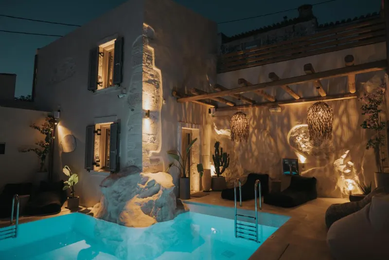 Illuminated courtyard pool at night with lanterns