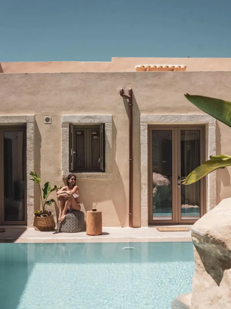 Woman relaxing poolside by stone building