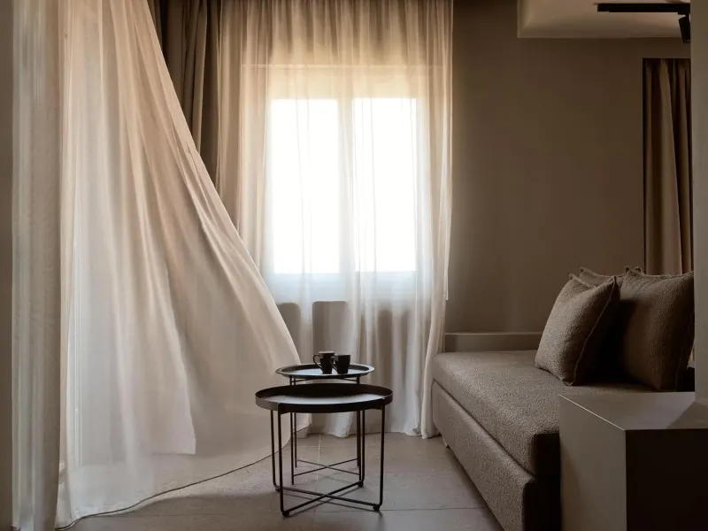 Curtain blowing in breeze near seating area