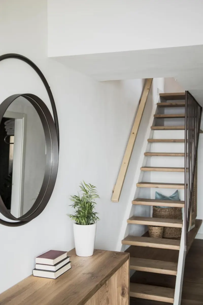 Staircase with round mirror and plant