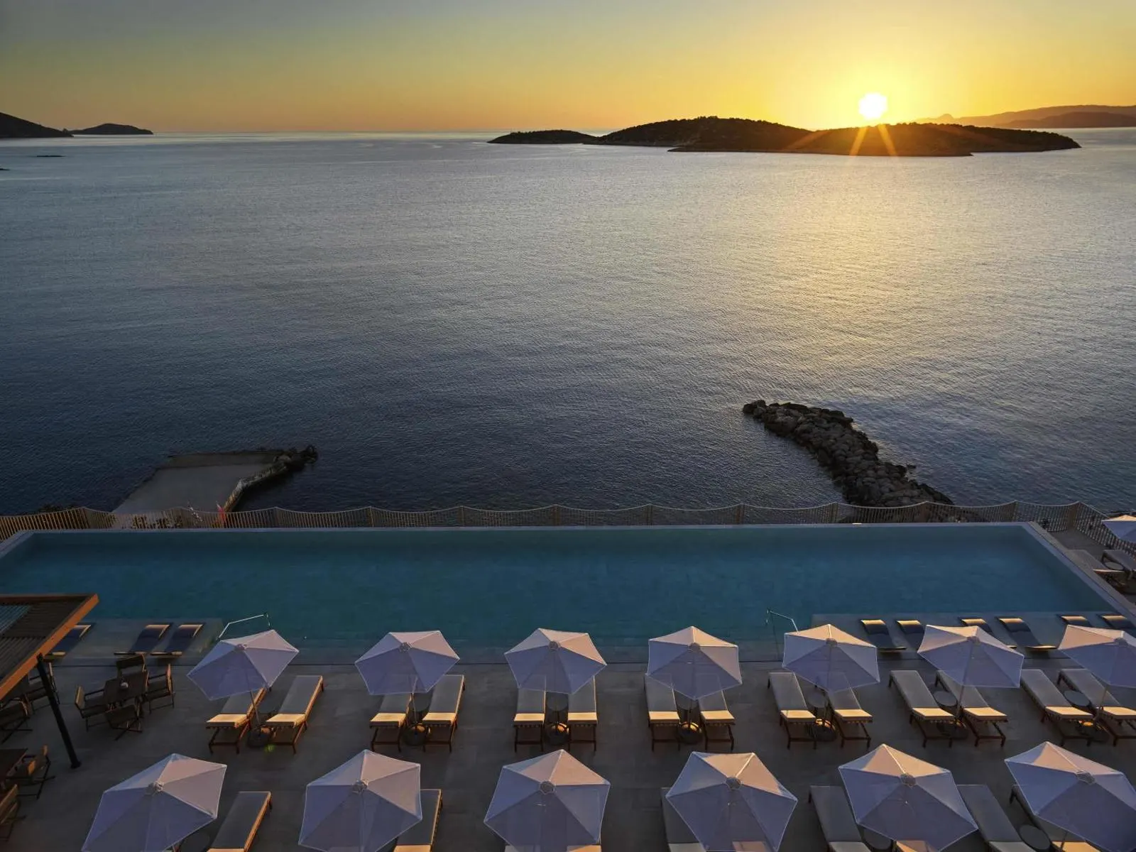 Sunset over sea viewed from infinity pool terrace
