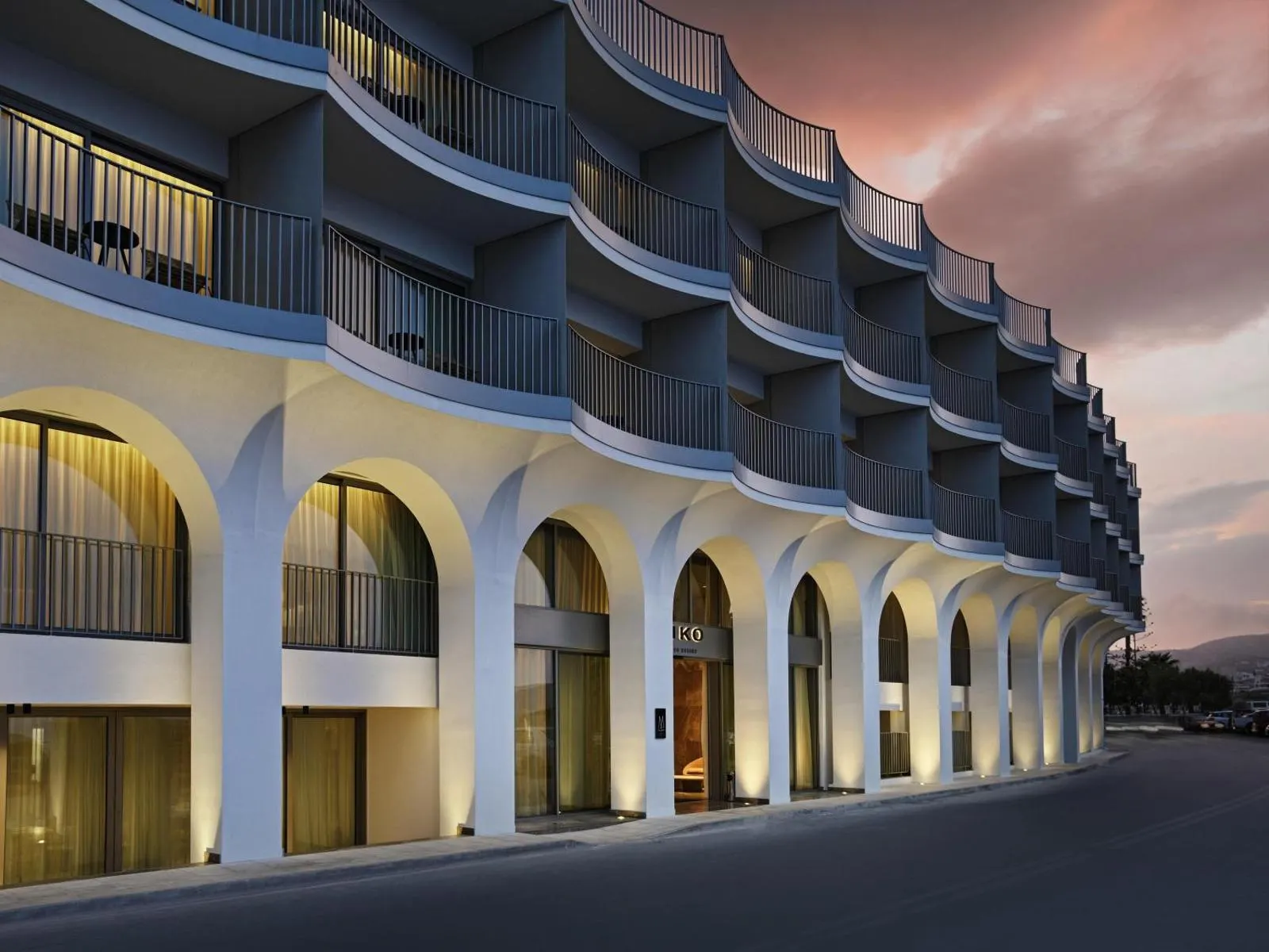 Arched hotel facade illuminated at dusk