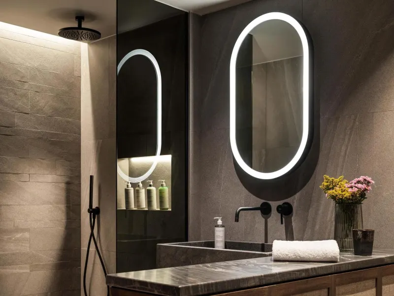 Bathroom vanity with illuminated mirrors and flowers