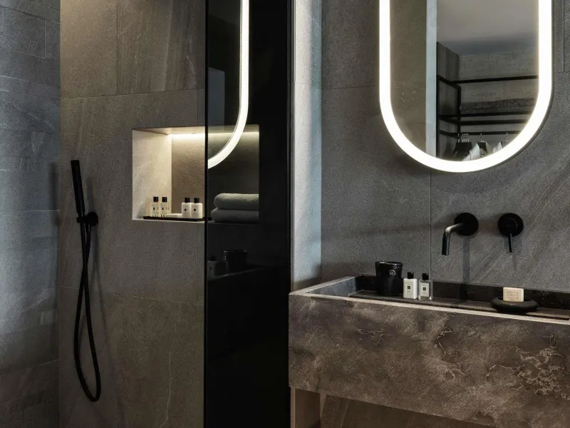 Dark stone bathroom with rain shower and vanity