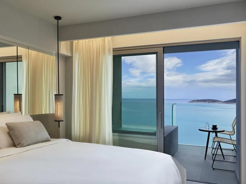 Bedroom with sea view through open balcony doors