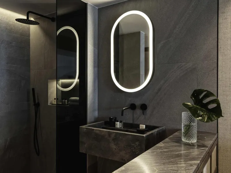 Modern bathroom with stone counter and oval mirrors