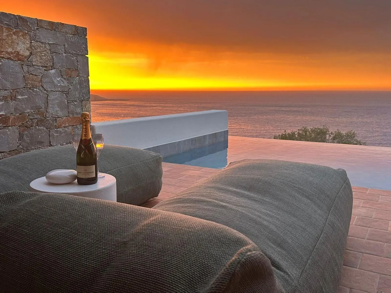 Sunset view from poolside loungers with champagne