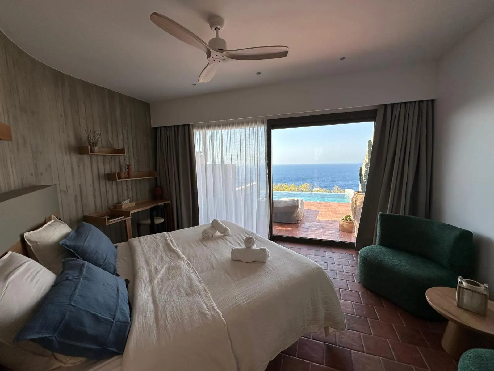 Bedroom with ceiling fan and sea view terrace