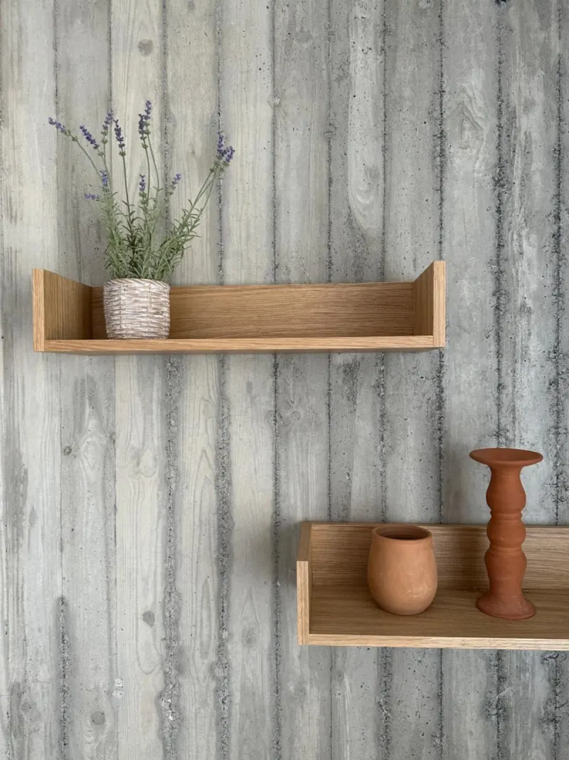 Wooden shelves with decor against textured wall
