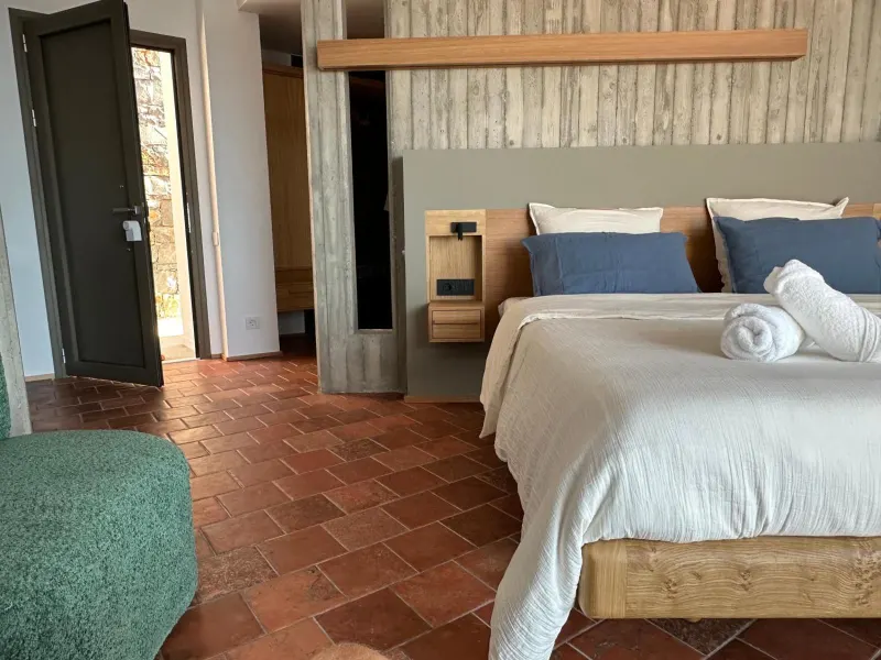 Bedroom with terracotta floor and wooden headboard