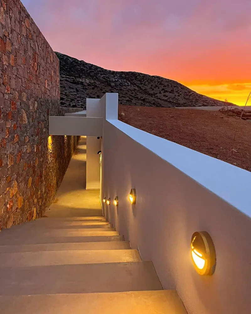 Stairway lit at sunset leading to villa