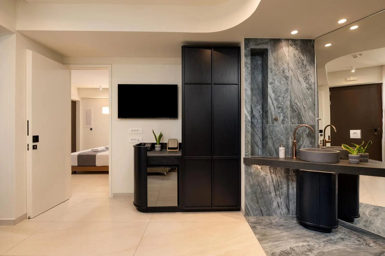 Suite hallway with marble sink and TV