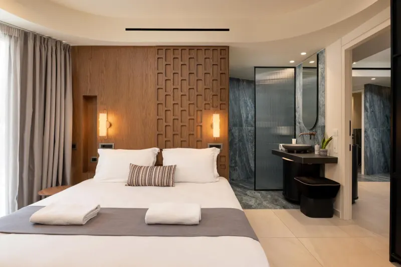 Bedroom with open bathroom and wood paneling
