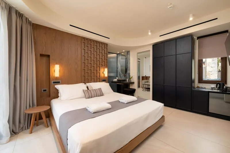 Bedroom with wooden headboard and kitchenette