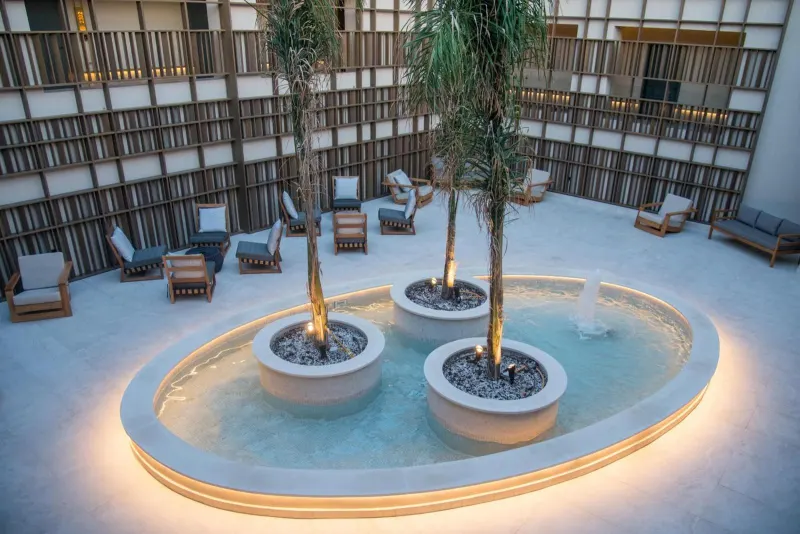 Courtyard fountain with palm trees at dusk