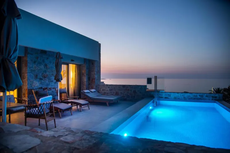 Private villa pool overlooking sea at twilight