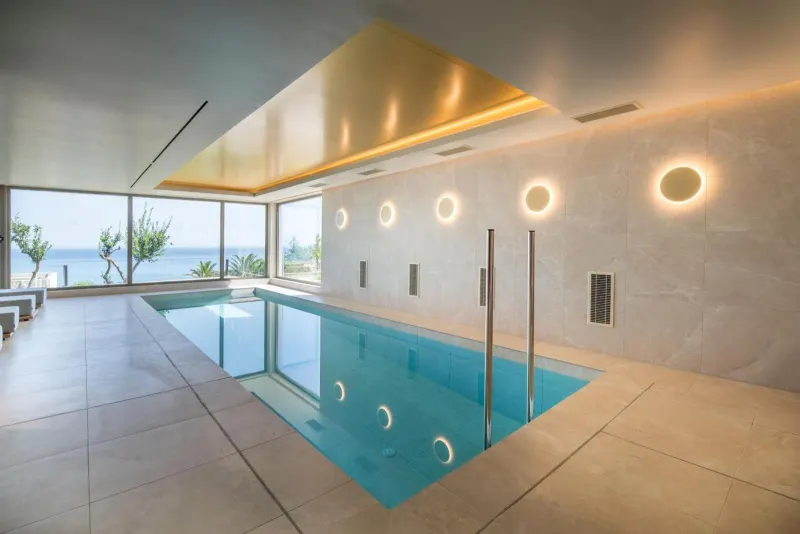 Indoor pool with sea view and modern lighting