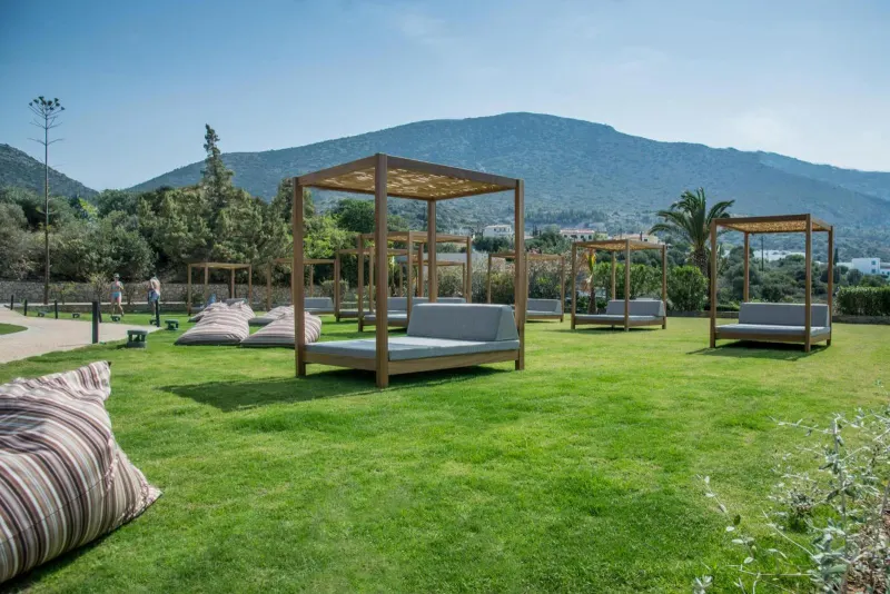 Outdoor lounge beds on lawn with mountain view