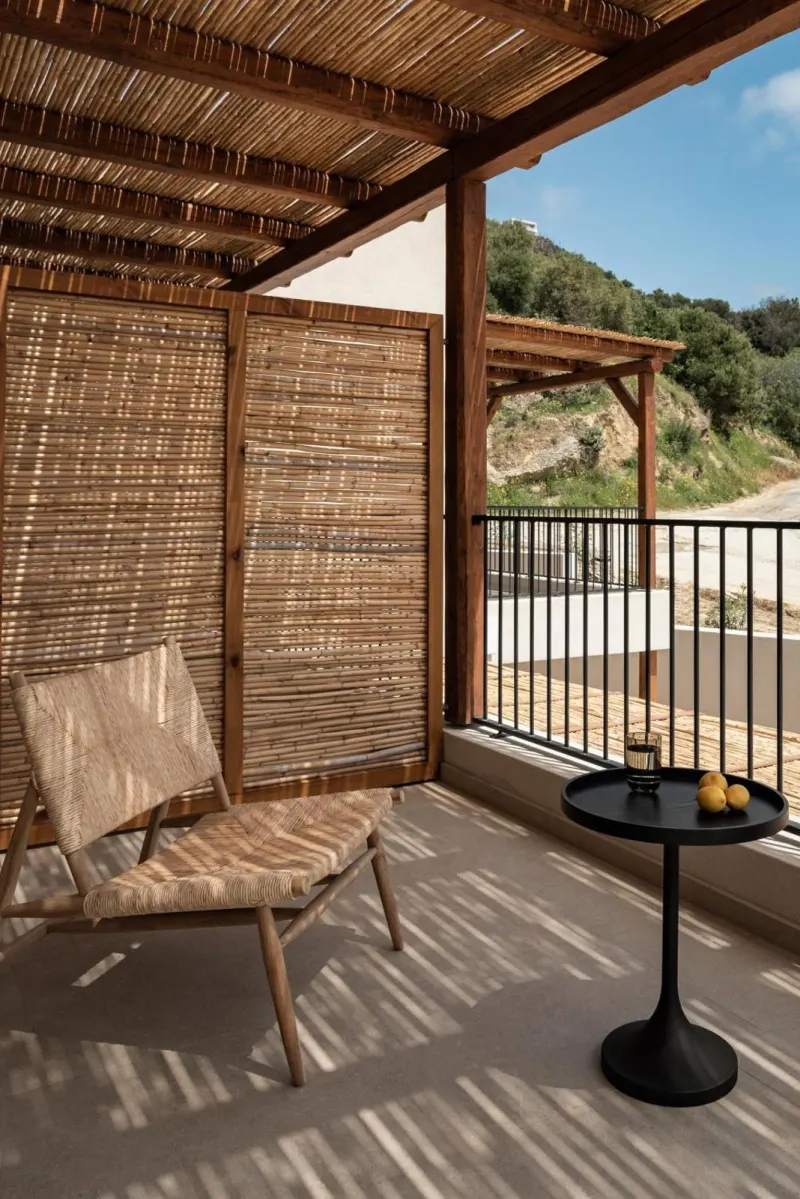 Woven chair on shaded balcony with hillside view