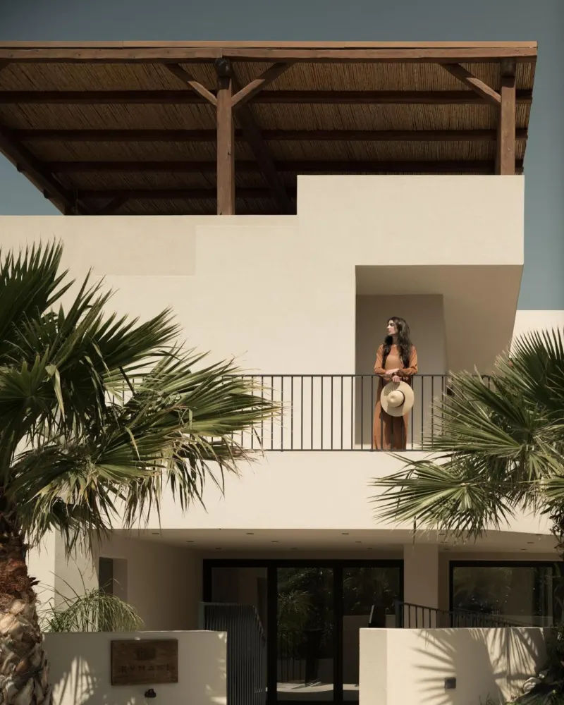 Woman standing on balcony of white building