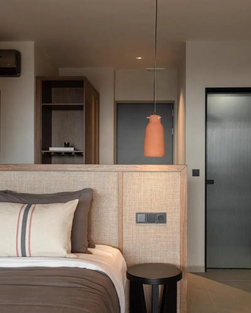 Bedroom corner with orange pendant light and headboard