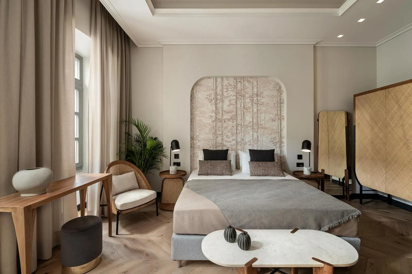 Bedroom with arched headboard and seating area