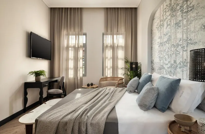 Bedroom with blue pillows and arched wall art