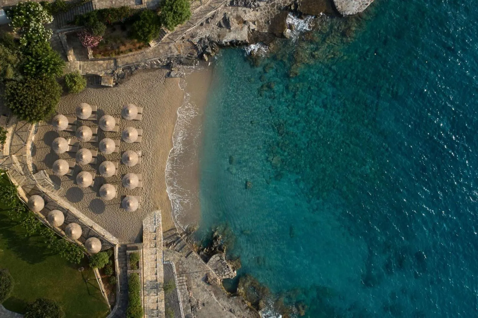 Aerial view of private beach with umbrellas and turquoise sea