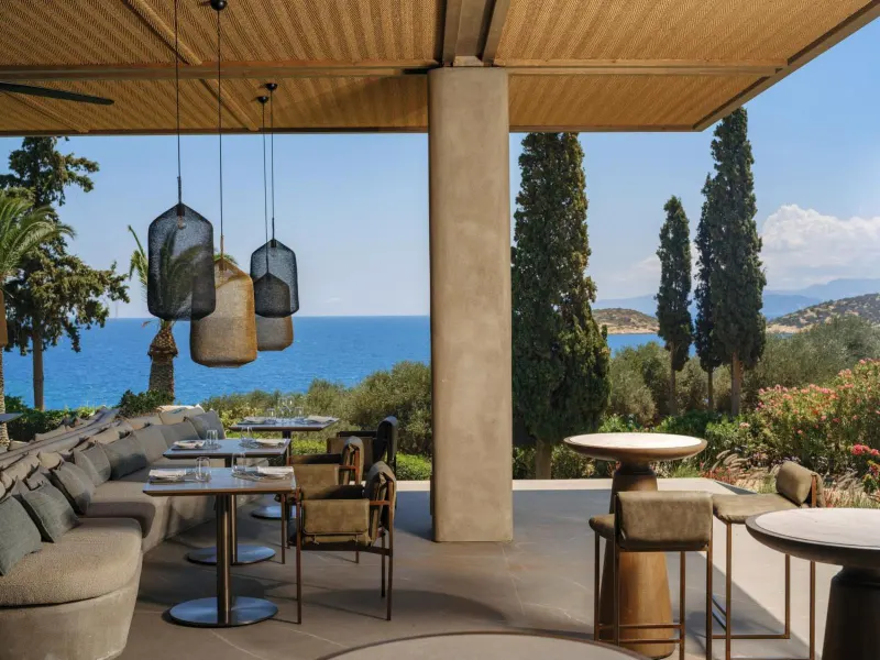 Terrace dining area with pendant lights and sea view