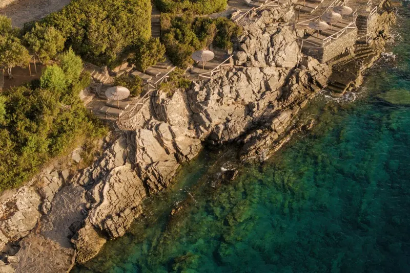 Aerial view of rocky coastline and swimmers