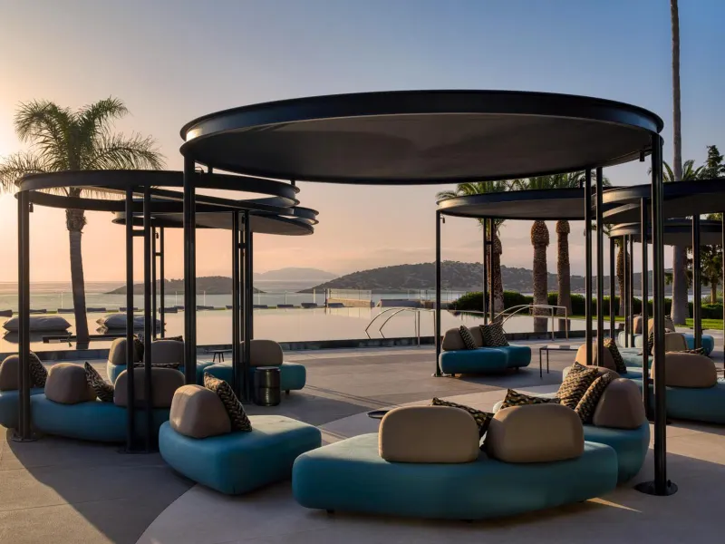 Poolside lounge seating with canopies at sunset
