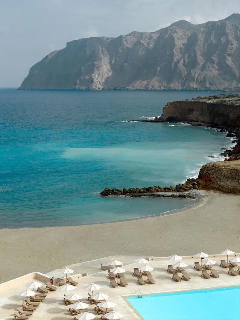 View of beach and pool overlooking dramatic cliffs