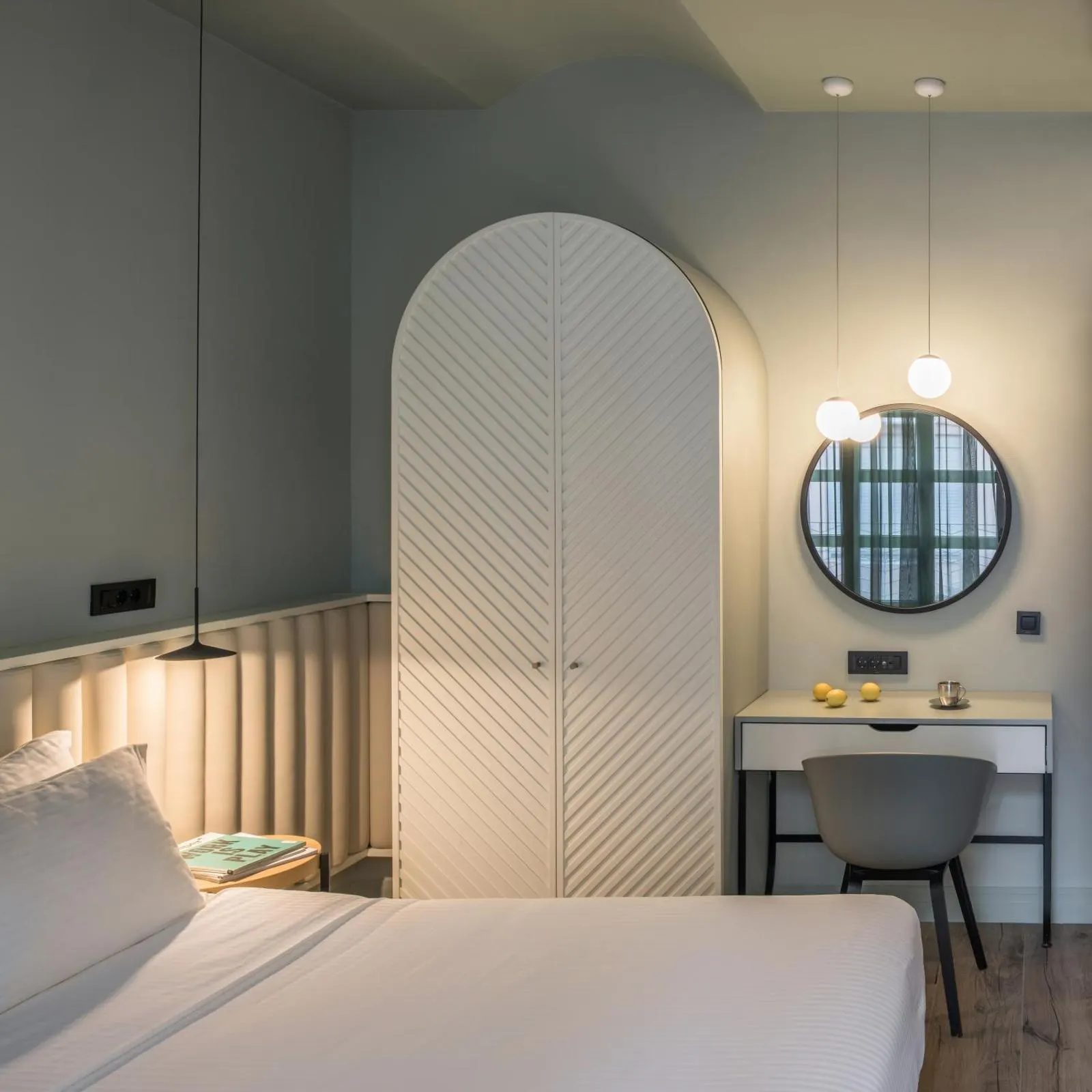 Bedroom with arched wardrobe and round mirror vanity