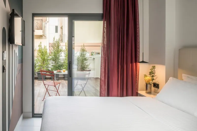 Bedroom with red curtains opening to balcony