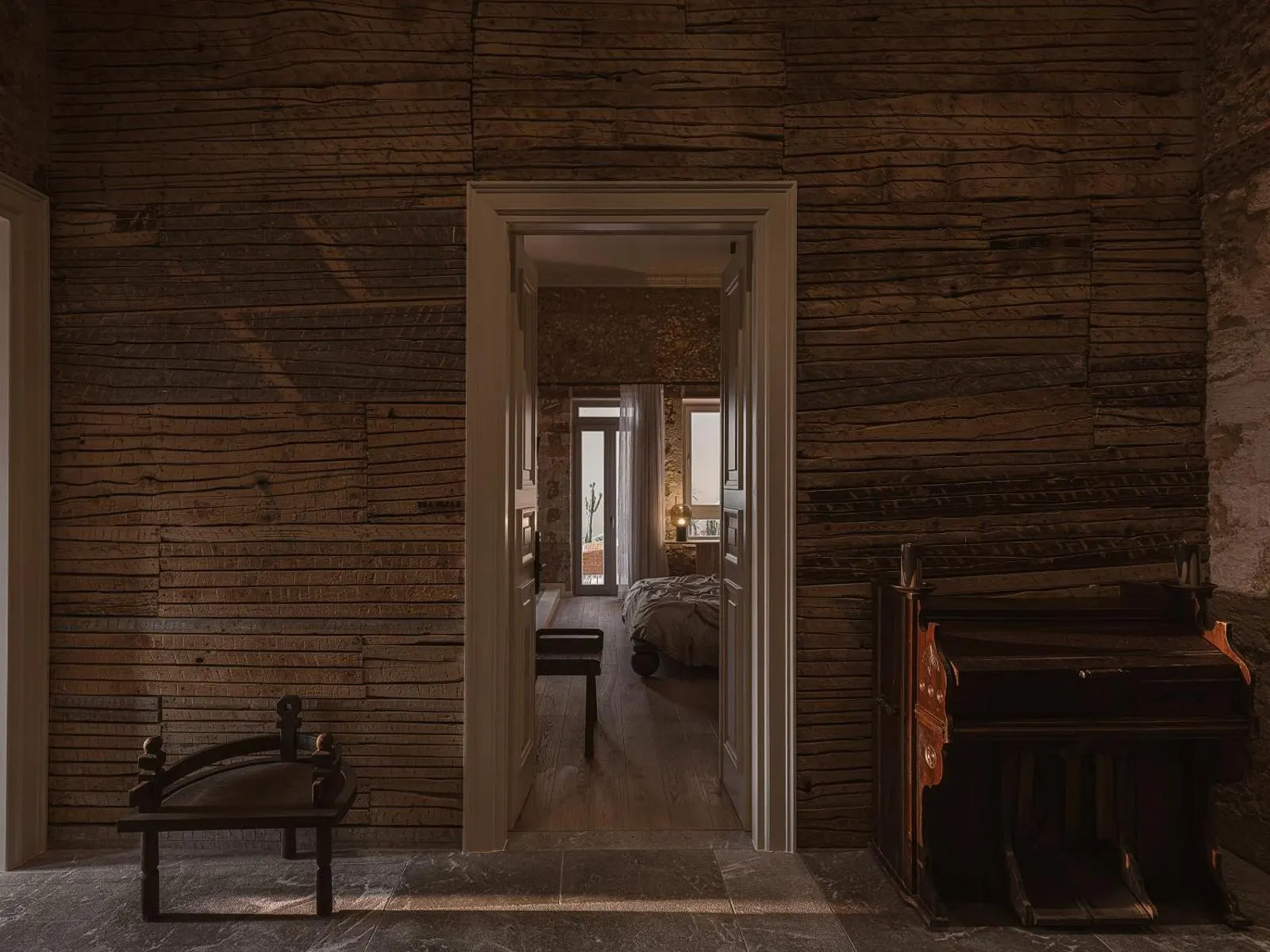 Rustic wood-paneled hallway leading to bedroom