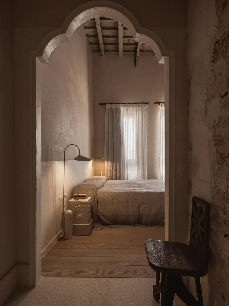 Arched doorway into cozy bedroom