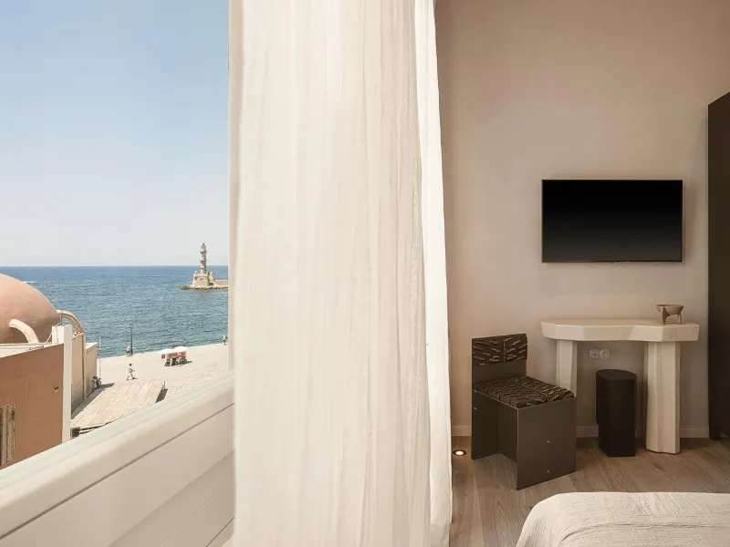 Room view of lighthouse and sea through curtain