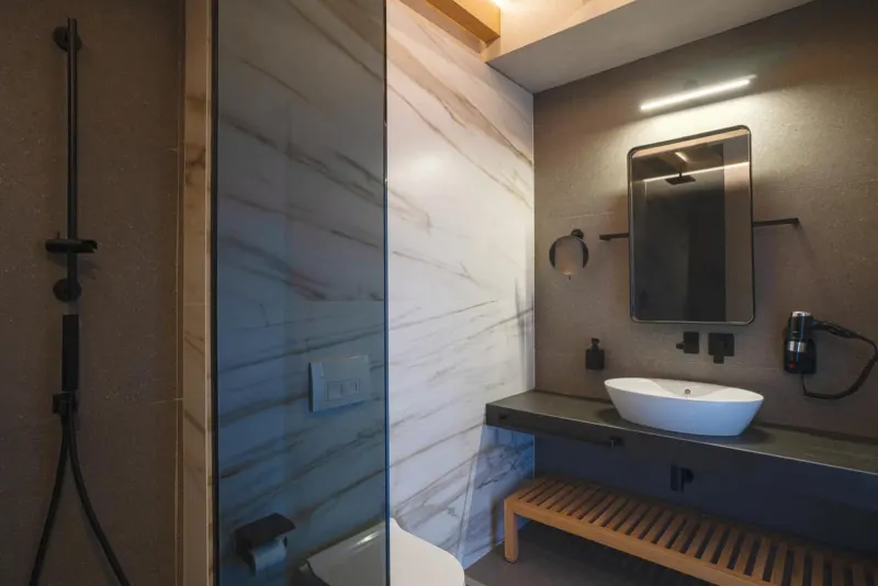 Bathroom with marble walls and glass shower