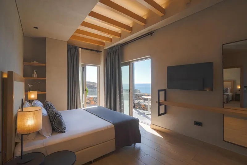 Sunlit bedroom with balcony and sea view
