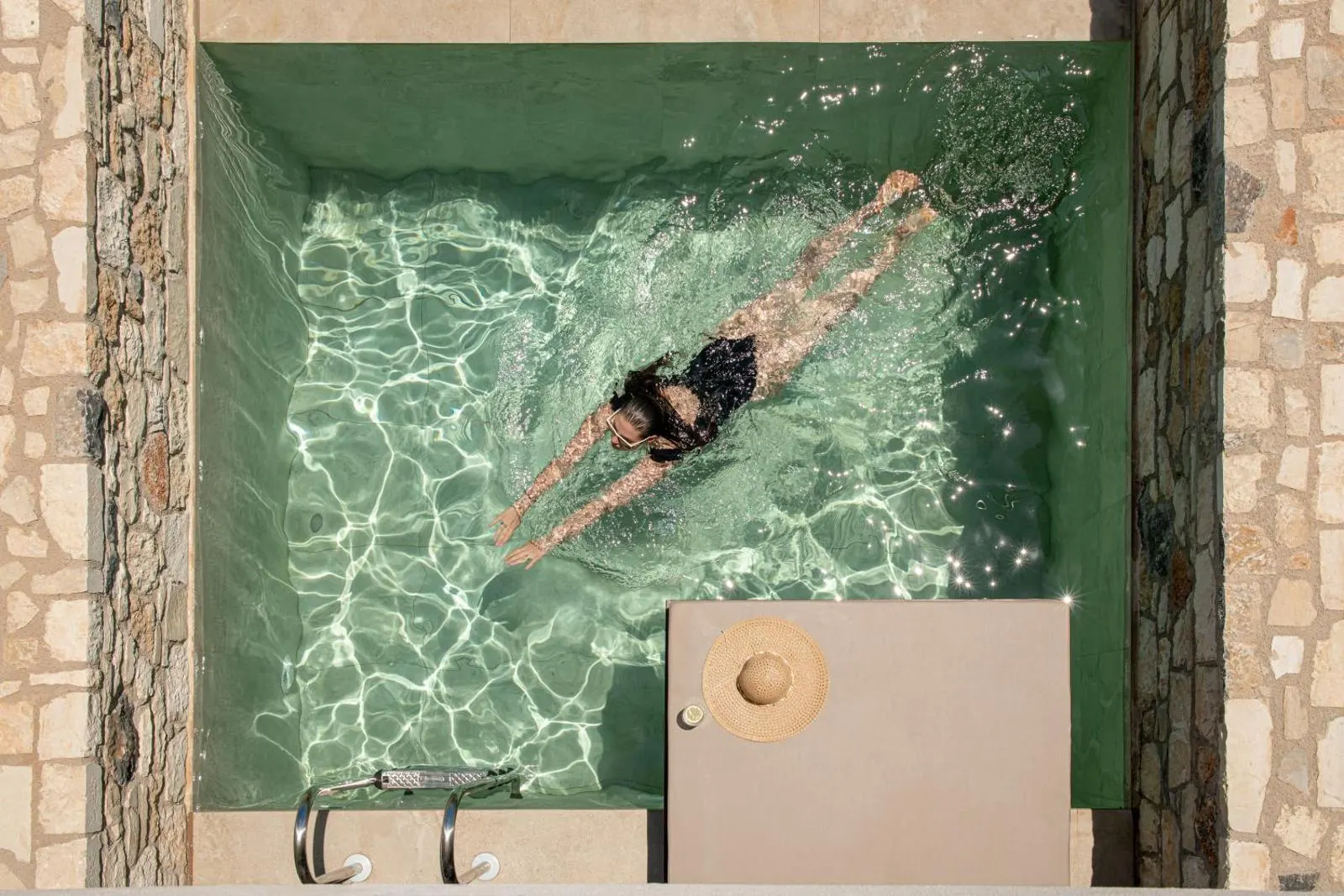 Aerial view of woman swimming in plunge pool